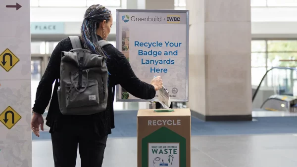 An attendee recycles a name badge and lanyard at Greenbuild & IWBC, the world’s largest event for green building professionals.